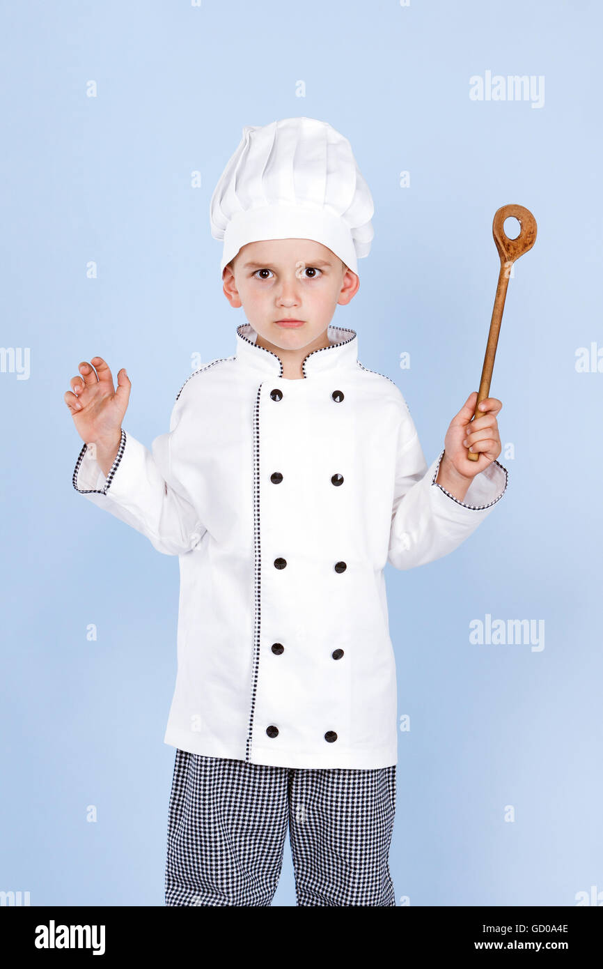 schlechter junge Koch mit einem Löffel in der hand Stockfoto