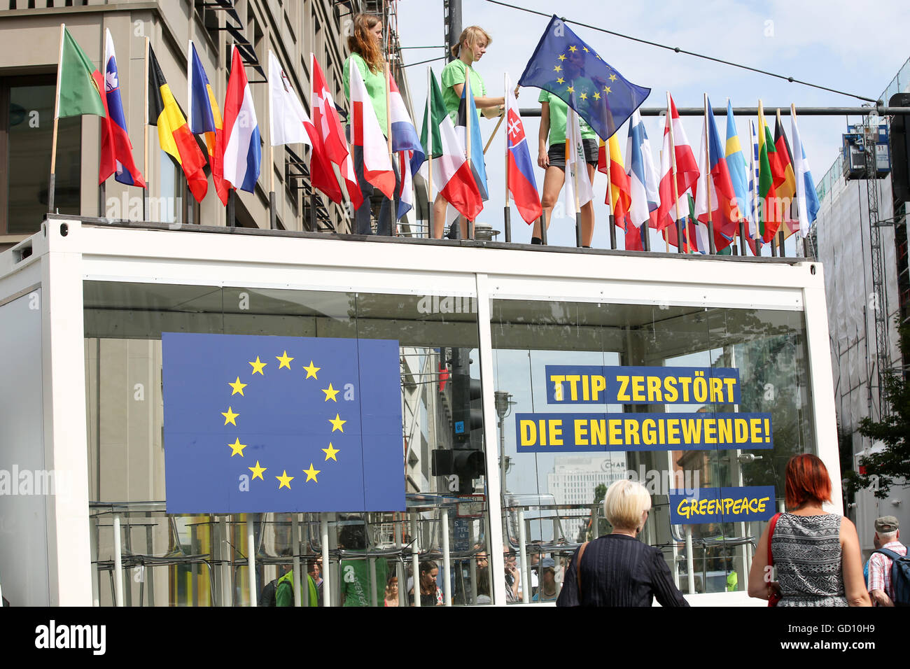 Greenpeace-Sprecher Christoph von Lieven (l) und anderen Greenpeace-Aktivisten protestieren mit einem Glas Lesesaal mit einem Banner zu lesen 'TTIP zerstört die Energiewende' in Berlin, Deutschland, 11. Juli 2016. Sie haben Congreated vor der Delegation der Europäischen Kommission am Pariser Platz in der deutschen Hauptstadt. In der Klage gegen das geplante Freihandelsabkommen TTIP Greenpeace bisher geheimen TTIP-Dokumente der Öffentlichkeit vorgestellt. Zur gleichen Zeit in Brüssel begann die 14. Runde der Verhandlungen über das geplante Freihandelsabkommen. Foto: BODO MARKS/dpa Stockfoto