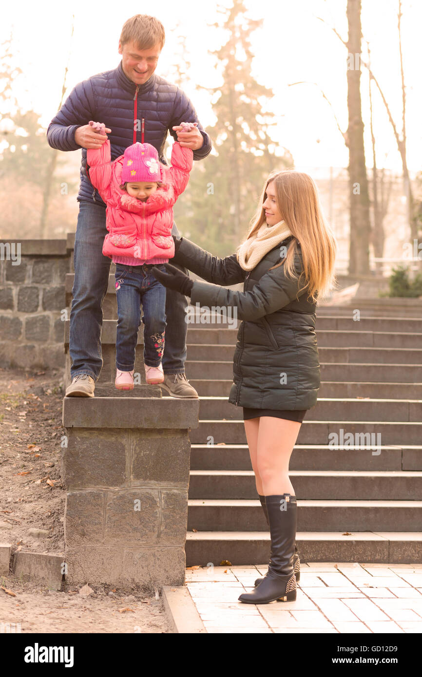 Glückliche Familie mit Töchterchen auf Spaziergang im Park Stockfoto