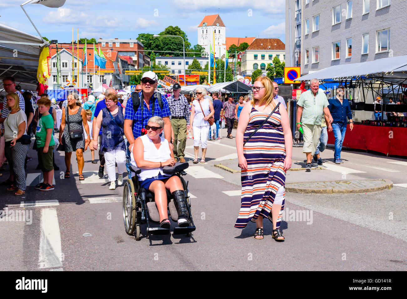 Ronneby, Schweden - 9. Juli 2016: Grosse öffentliche Markttag in der Stadt mit vielen Menschen. Hier ist eine weibliche Person in einem Rollstuhl Pusche Stockfoto