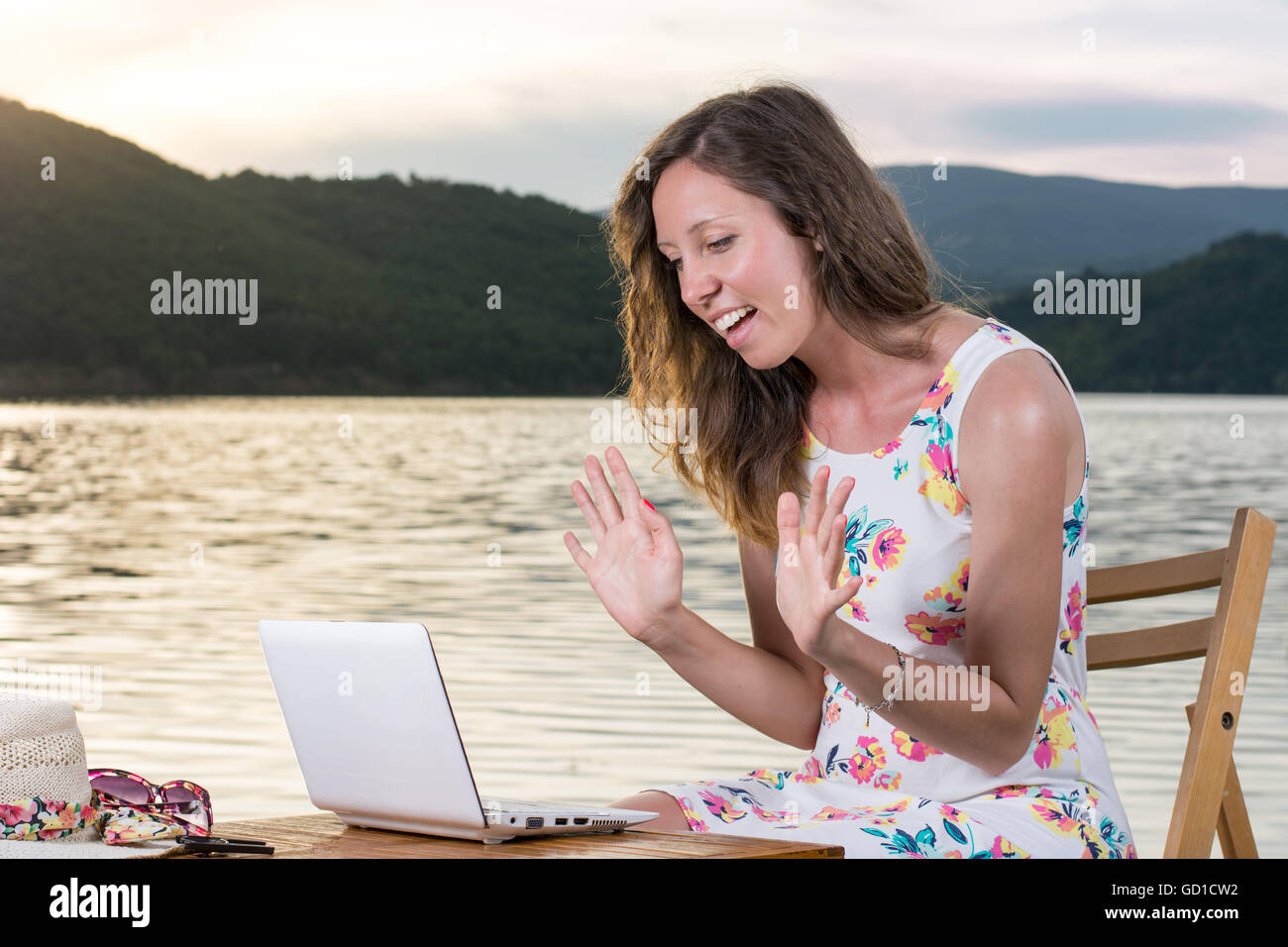 Junge Frau, die einen Videoanruf am See Stockfoto