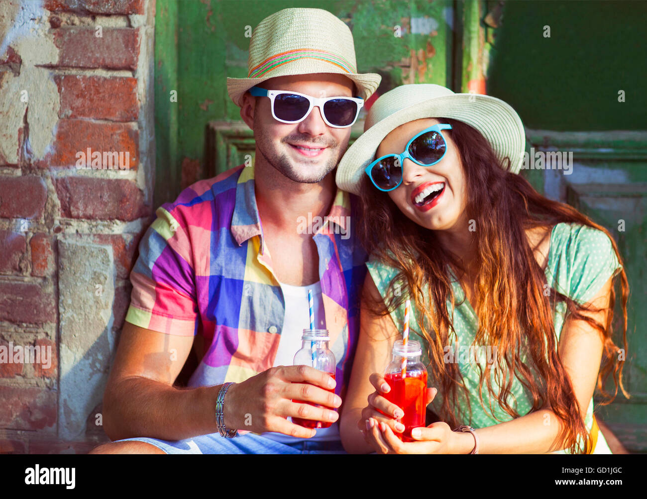 Glückliches junges Paar auf der Straße tragen Hüte und Sonnenbrillen. Urlaub und Reisen-Konzept Stockfoto