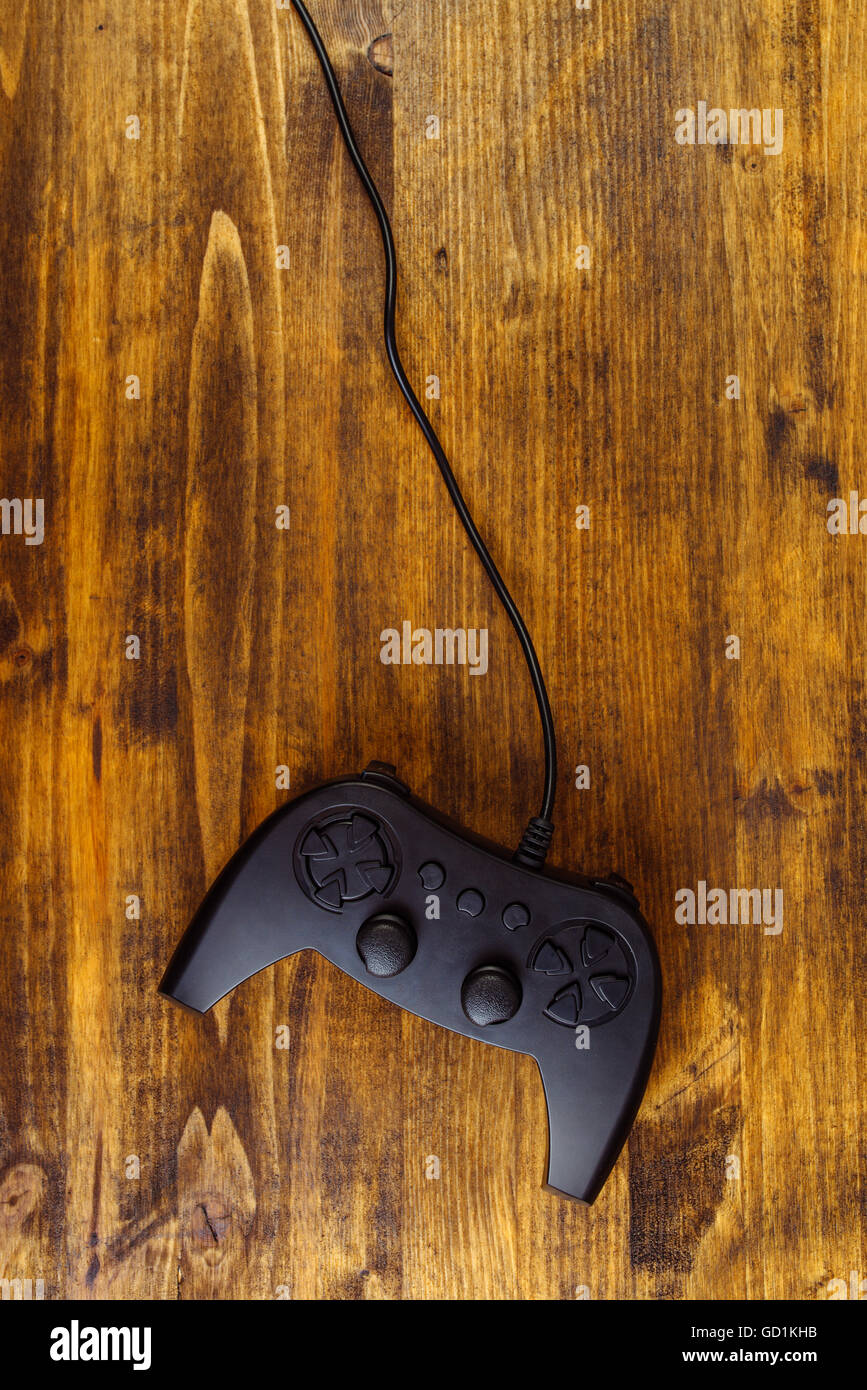 Gamepad-Controller auf hölzernen Schreibtisch flach legen Draufsicht, Gaming- und Entertainment-Konzept mit Textfreiraum Stockfoto