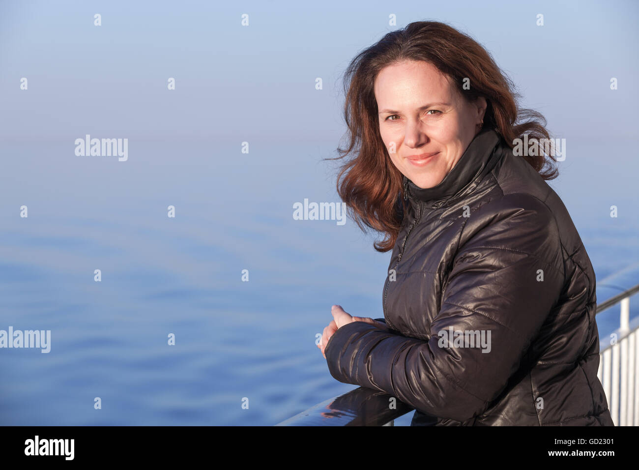 Schönen lächelnden jungen kaukasischen Frau steht auf dem Fuß Deck des Kreuzfahrtschiffes, Outdoor-Porträt Stockfoto