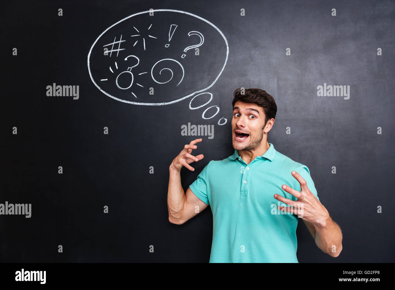 Wahnsinnig gereizt jungen Mann stehen und schreien über Tafel Hintergrund Stockfoto