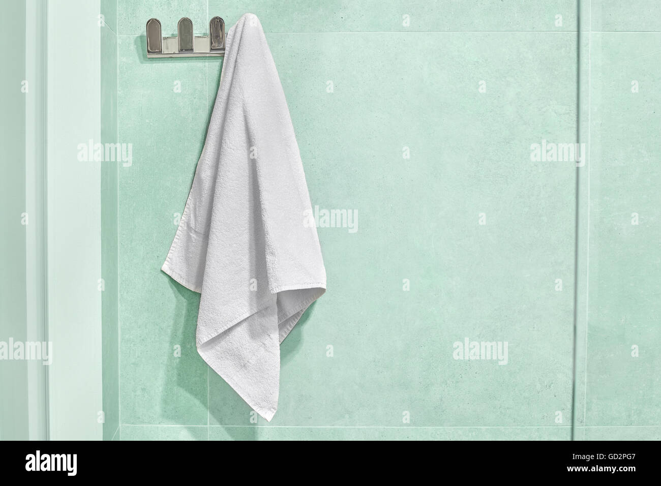Weißes Handtuch aufhängen an einer Wand im Badezimmer. Stockfoto
