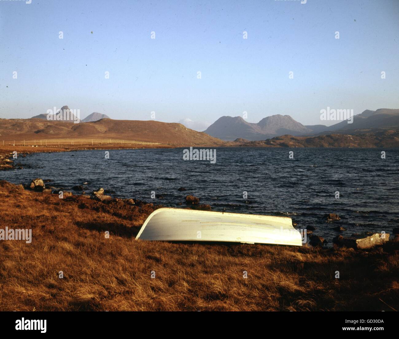 Schottland, Sutherland. Loch Osaig mit den Strahlen der untergehenden Sonne fangen den Konus der Stac Polly und Beinn eine Eain. Ca. 1975. Stockfoto