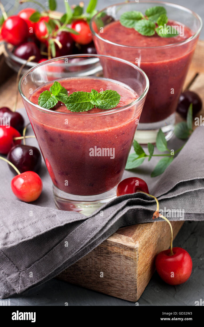 Smoothie mit Kirschen in ein Glas, eine Mischung von Süßkirschen auf konkrete Hintergrund Stockfoto