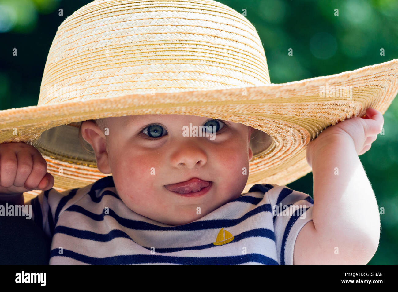 Baby Boy mit Stroh Sonnenhut Stockfoto