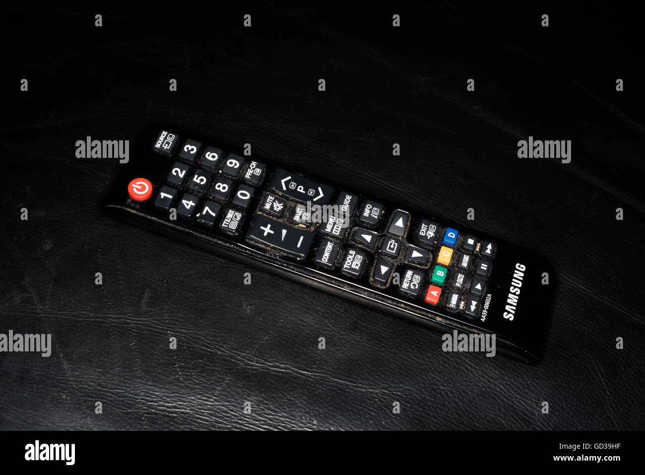 Samsung TV-Fernbedienung auf schwarzem Ledersofa Stockfoto