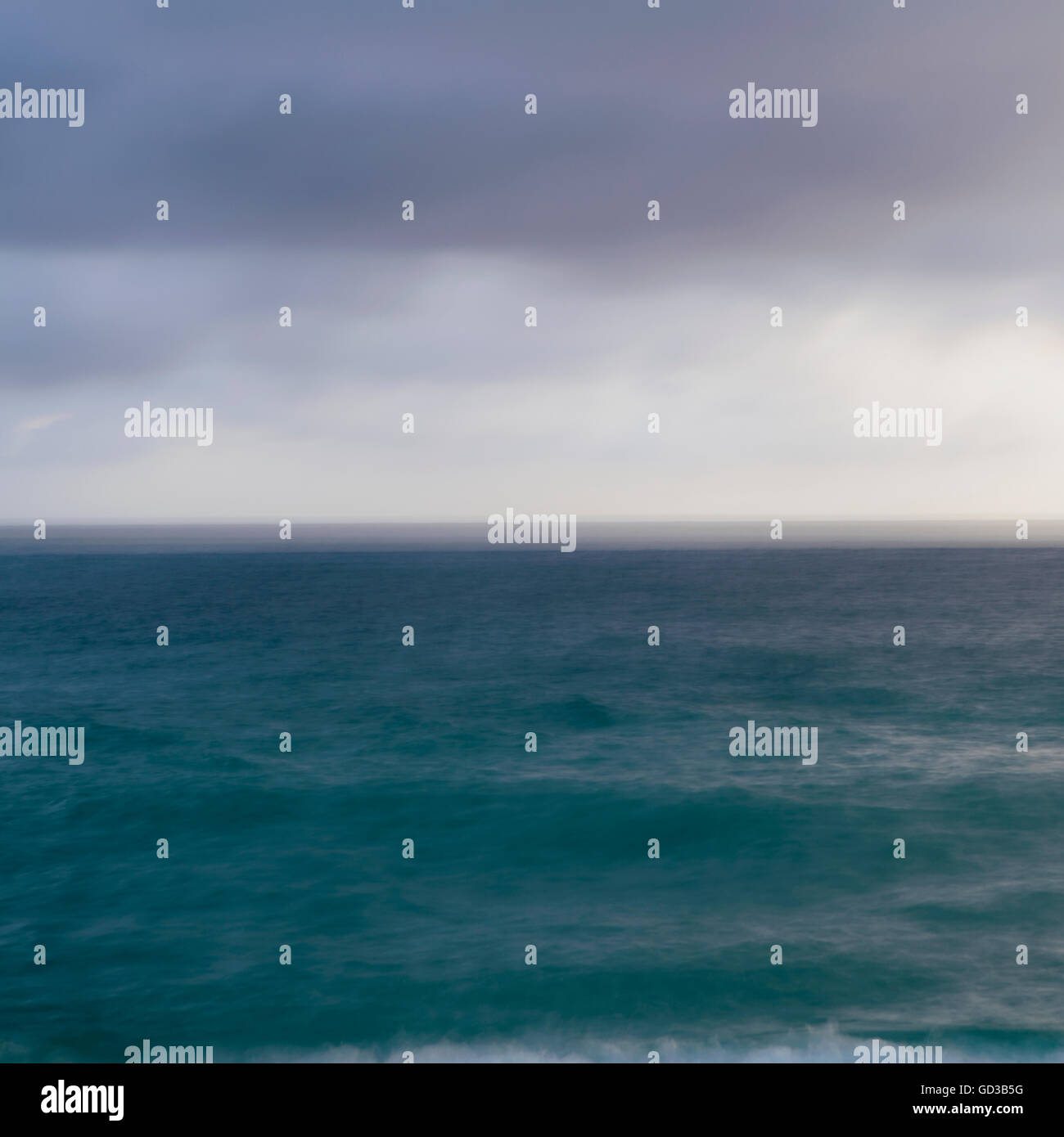 Türkisblaue Meeresoberfläche unter einem grauen stürmischen Himmel. Stockfoto