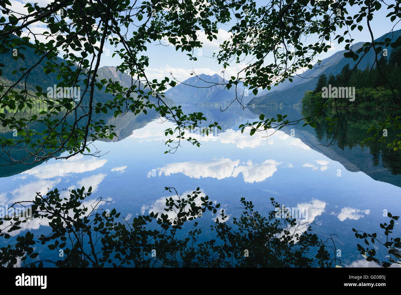 Reflexionen, Spiegel, Himmel und Wolken spiegelt sich in der Oberfläche des Wassers des Lake Crescent. Stockfoto
