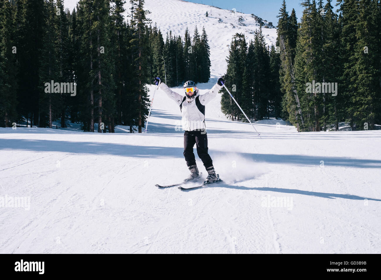 Ein Skifahrer, streckte eine junge Frau auf den Skiern mit ihren Armen, auf der Piste. Stockfoto