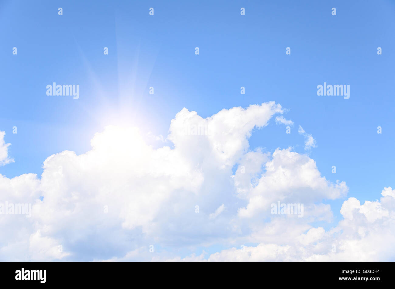 Die Sonne hinter einer Wolke gegen den blauen Himmel. Stockfoto