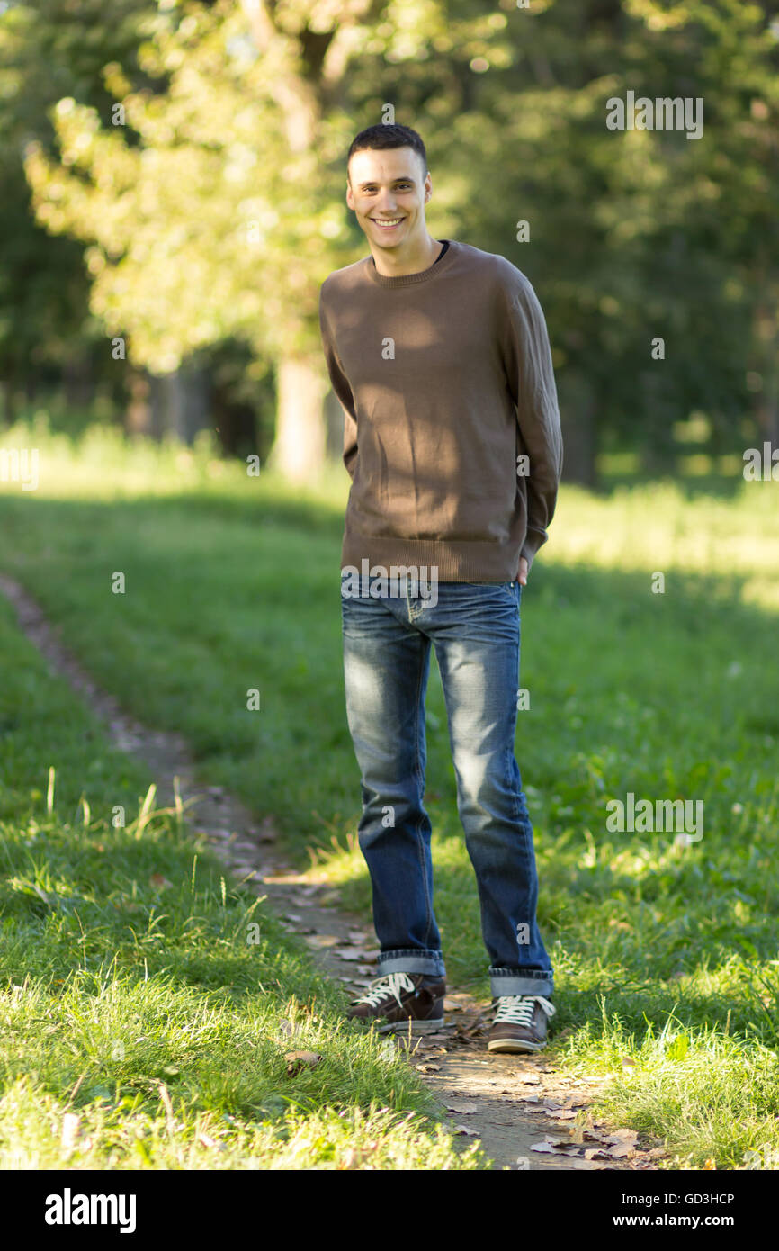 Ganzkörper-Schuss von junger Mann lächelnd Rasen Feld unbefestigte Straße 20 Stockfoto