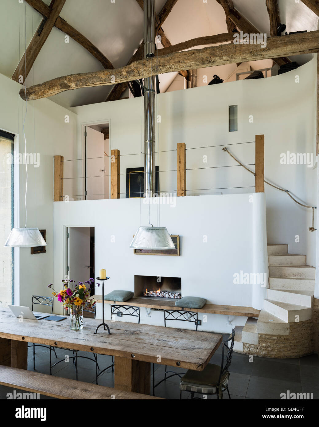 Strahlte in doppelter Höhe Scheune Konvertierungen mit dem Refektorium Stil Tisch und Gas Feuer Decke Stockfoto