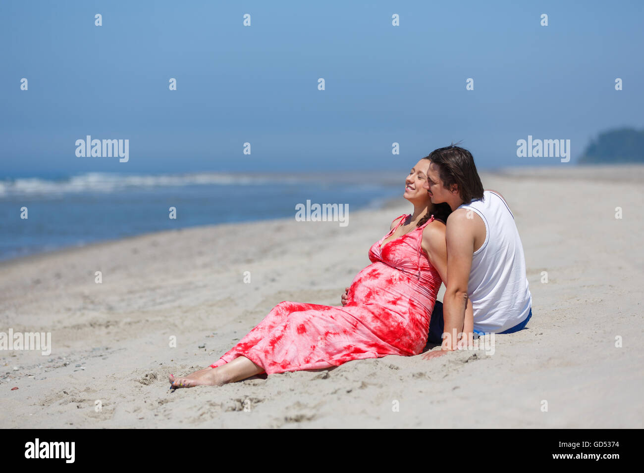 Das schwangere paar umarmt am Strand, Sommerzeit Stockfoto