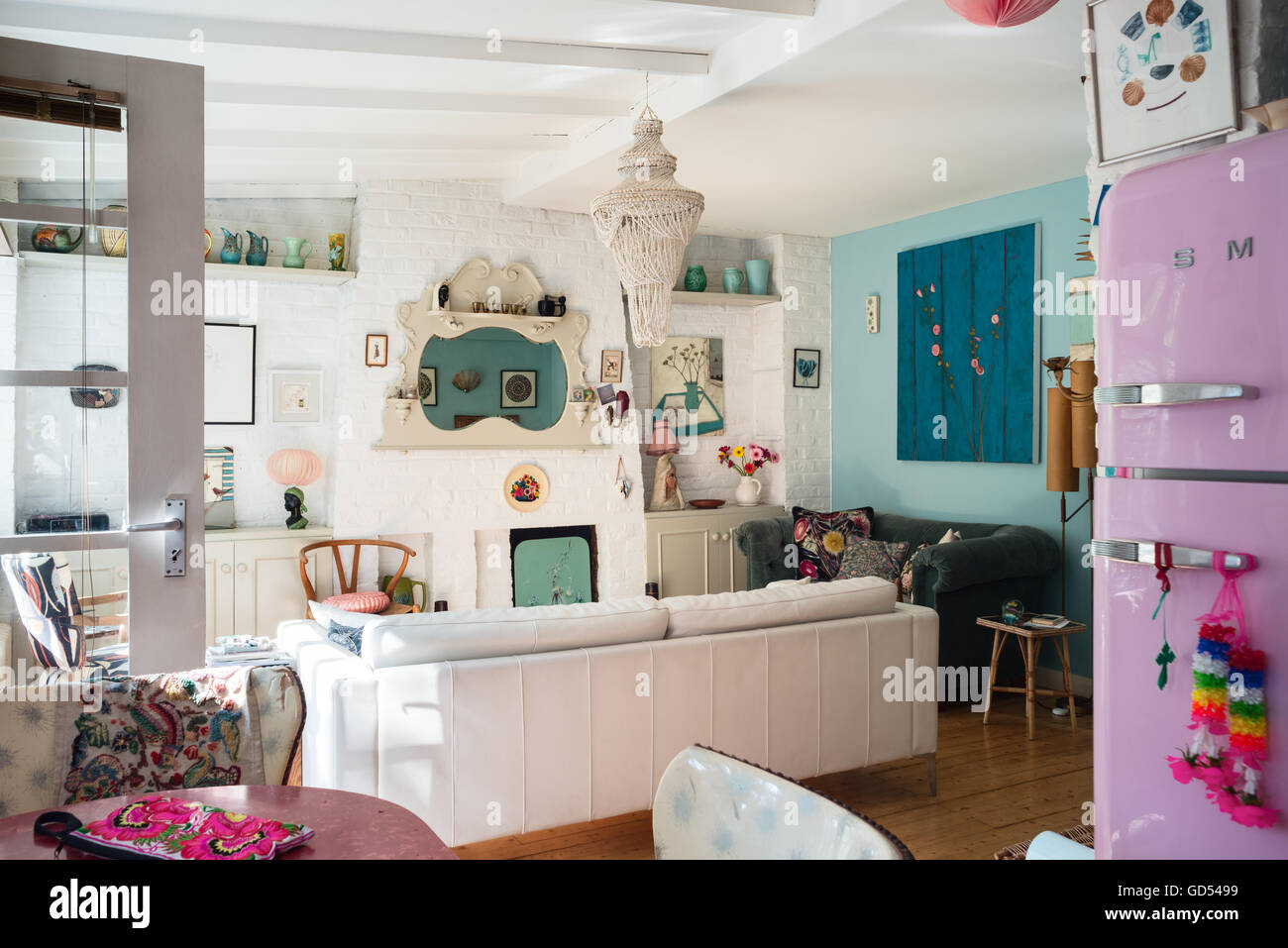Helle Wohnküche mit Kaminsims Spiegel, Hans Wegner "Wishbone" Stuhl und dekorative Keramik, die auf einem hohen Regal angezeigt Stockfoto