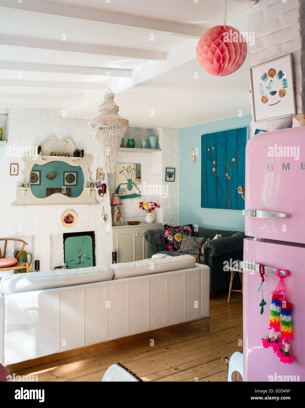 Helle Wohnküche mit Kaminsims Spiegel und Retro-Stil rosa Smeg Kühlschrank Stockfoto