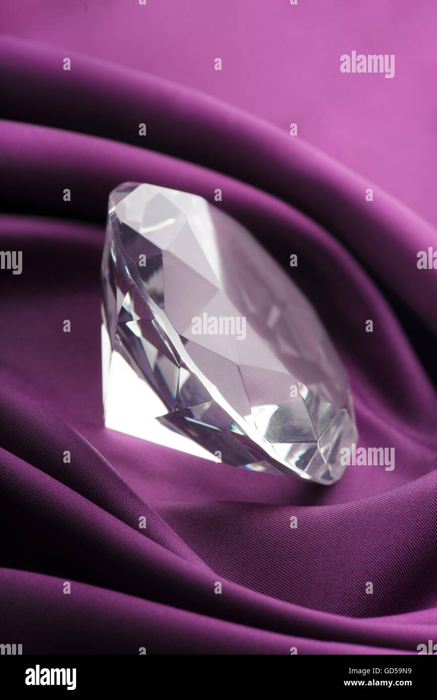 Teure transluzente Diamond über lila Seide Stoff Stockfoto