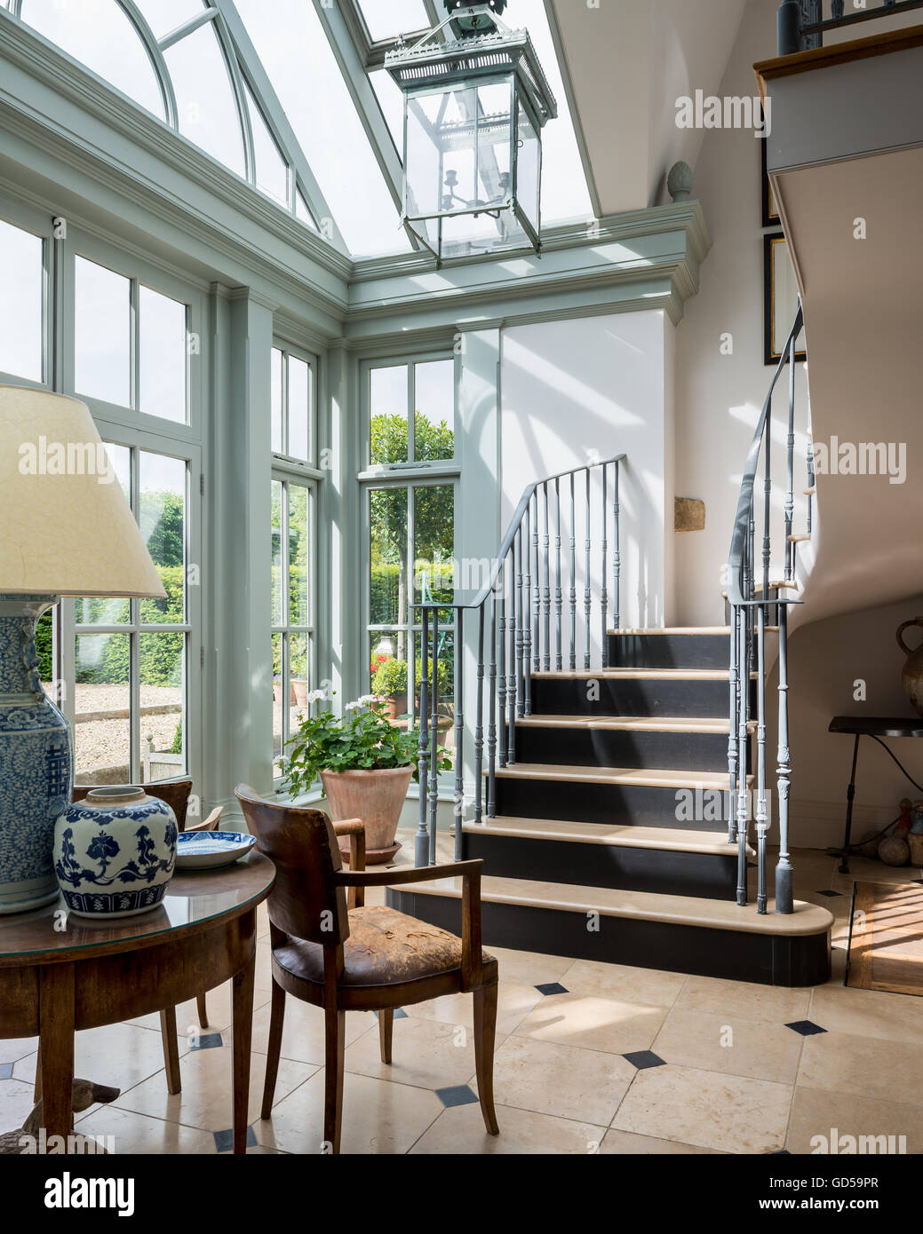 Alte Brücke Ledersesseln und runder Tisch in der Eingangshalle mit Stein und Metalltreppe Stockfoto