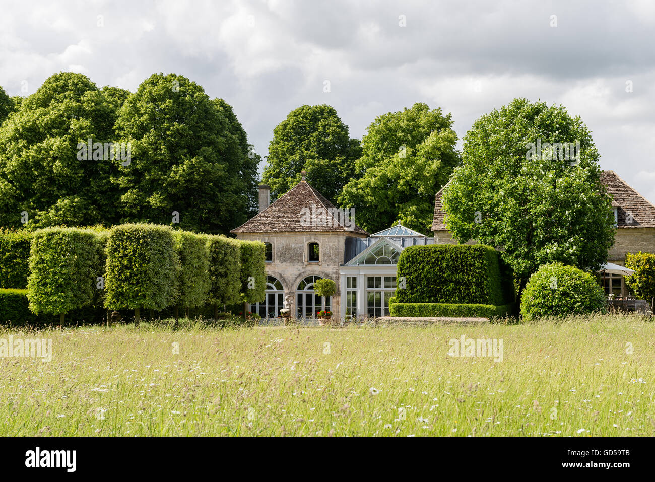 Außenfassade des konvertierten Trainer Häuser mit Blumen Wiese und Eiben Hecke Stockfoto