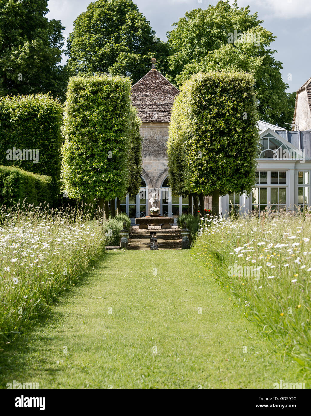 Außenfassade des konvertierten Trainer Häuser mit Blumen Wiese und Eiben Hecke Stockfoto