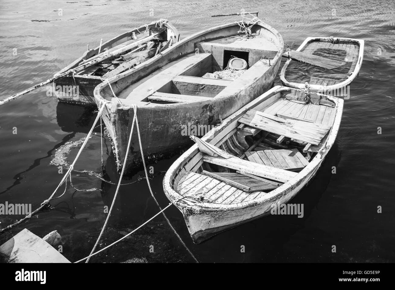 Alte hölzerne Fischerboote vertäut im kleinen Hafen von Avcilar, Stadtteil von Istanbul, Türkei. Schwarz / weiß Retro-stilisierte Foto Stockfoto