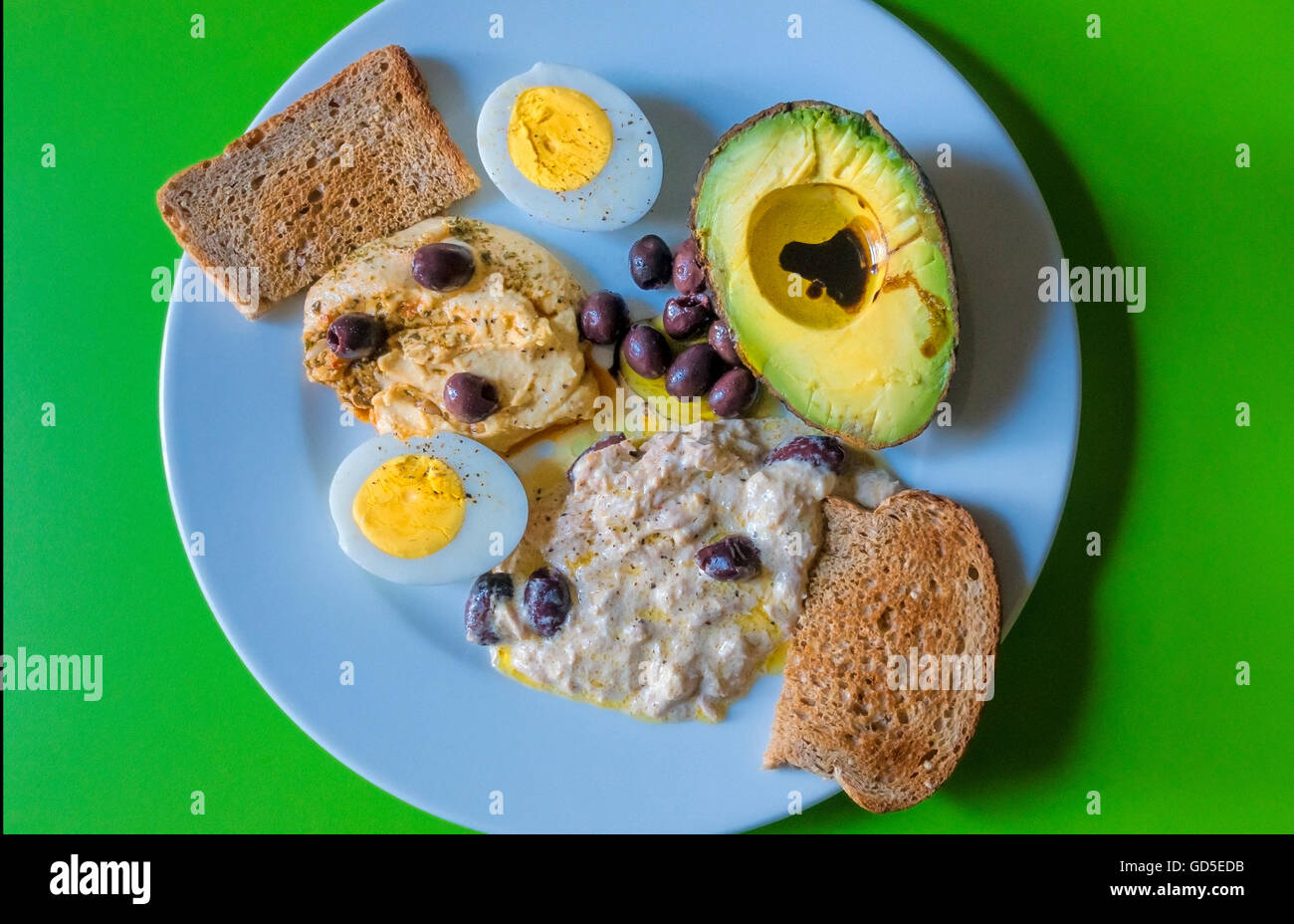 Kalte Speisen: Humus, Thunfisch-Salat, Oliven, gekochtes Ei, Vollkorn Toast Stockfoto