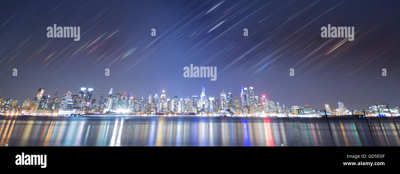 Skyline New Yorks Nacht, mit bunten Wasserspiegelungen und geschichteten Motioin Linien. Stockfoto