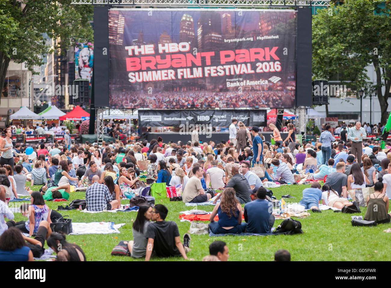 Tausende von Menschen ihre decken zu verbreiten und behaupten, ihre Plätze im Bryant Park in New York auf Montag, 11. Juli 2016 für die HBO Bryant Park Summer Film Festival. Der Park zeigt Filme am Montagabend während des Sommers zieht eine Vielzahl von Besuchern und bis zu schätzungsweise 8000 Menschen. (© Richard B. Levine) Stockfoto