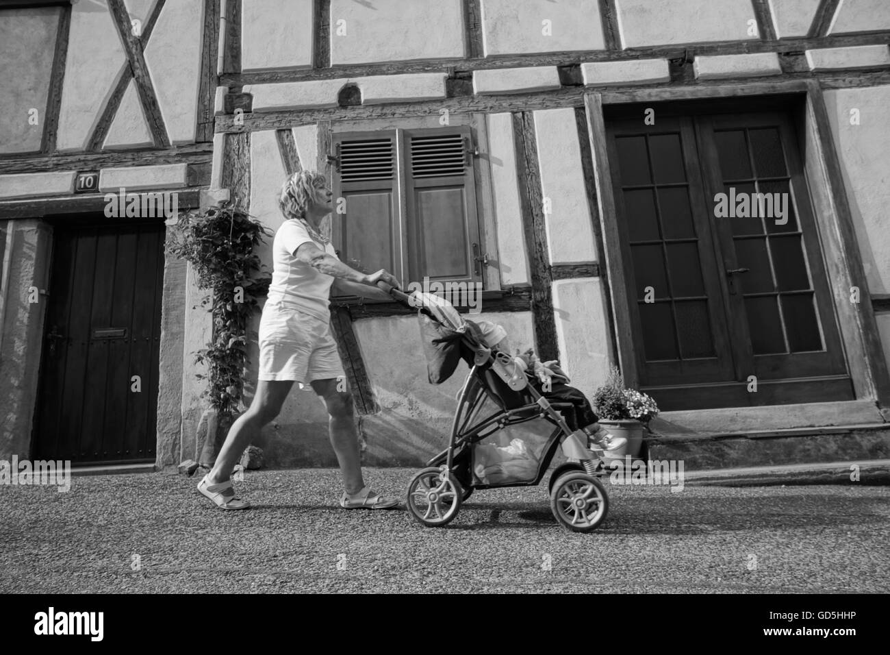 Frau schieben Kinderwagen, Riquewihr, Colmar, Frankreich Stockfoto