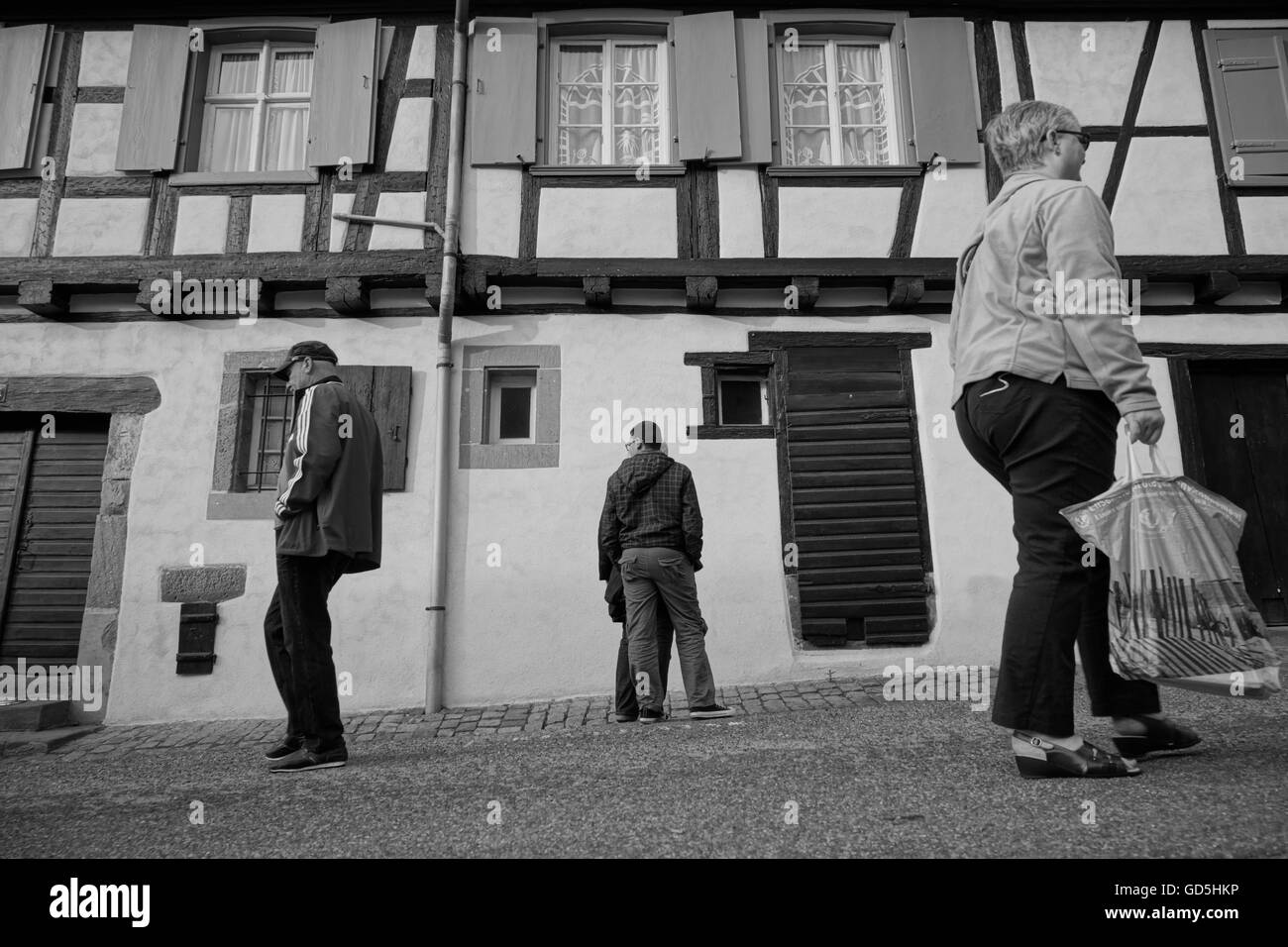 Drei Menschen, die zu Fuß in verschiedene Richtungen vor alten Haus in der Nähe von Paris, Frankreich Stockfoto