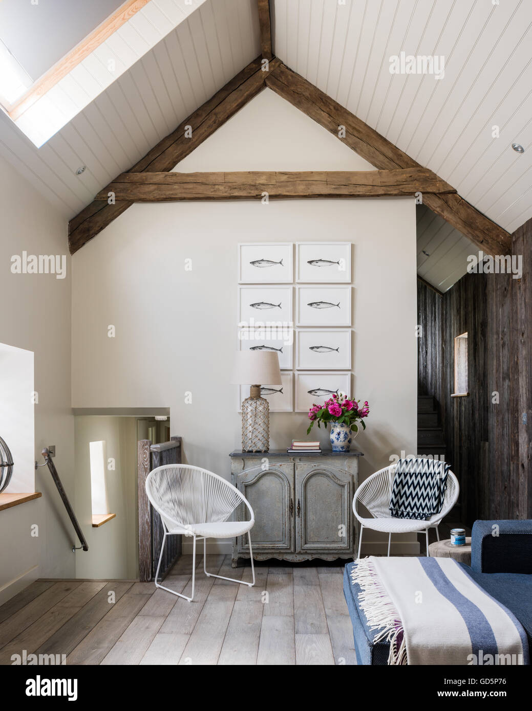 Makrele Federzeichnungen von Kate Stein an der Hütte Wohnzimmer mit Satteldach. Die weißen Stühle sind durch Pomax Stockfoto