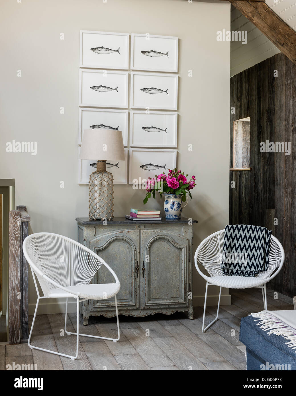 Makrele Federzeichnungen von Kate Stein an der Hütte Wohnzimmer mit Satteldach. Die weißen Stühle sind durch Pomax Stockfoto