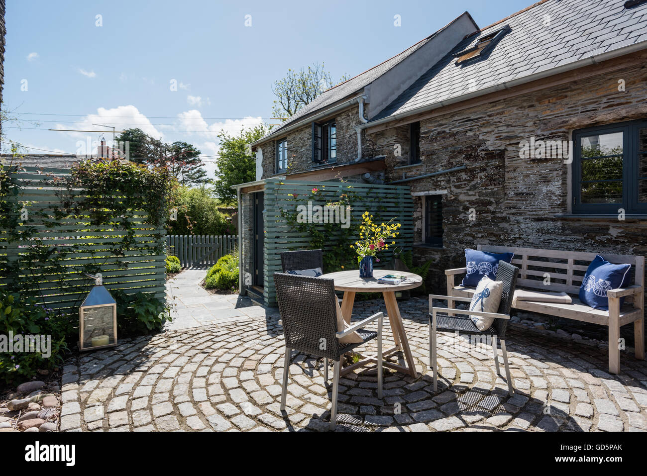 Gartenmöbel in Ferienhaus Innenhof mit kreisförmigen Ziegel paverc Stockfoto