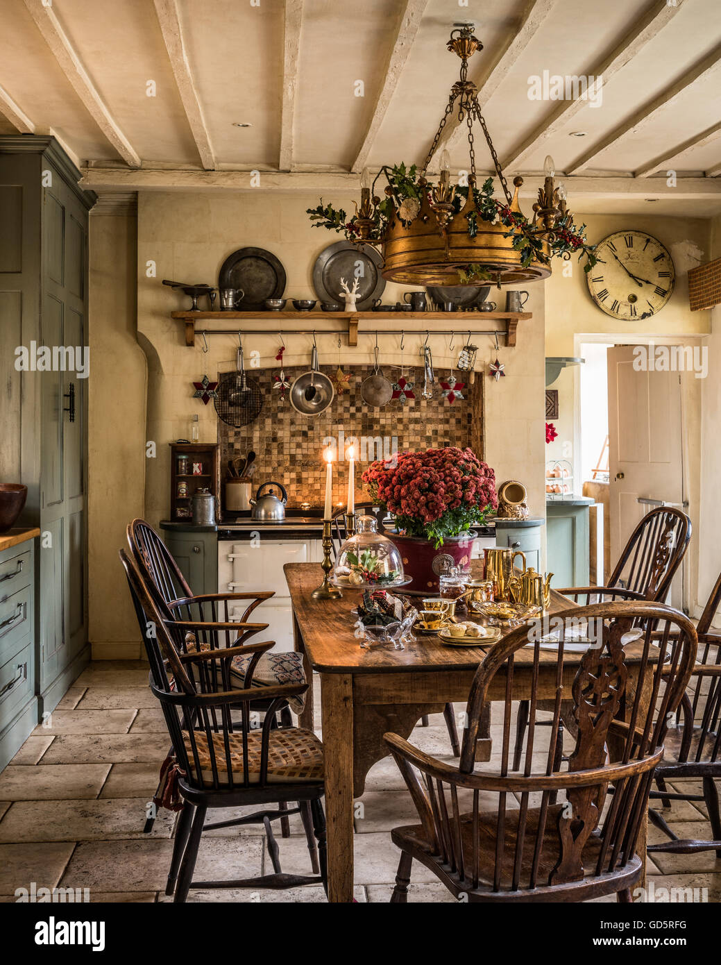 Brennende Kerzen und Gold plattiert Kaffee am Holztisch in Landhausküche von Surrey Pfarrhaus Stockfoto