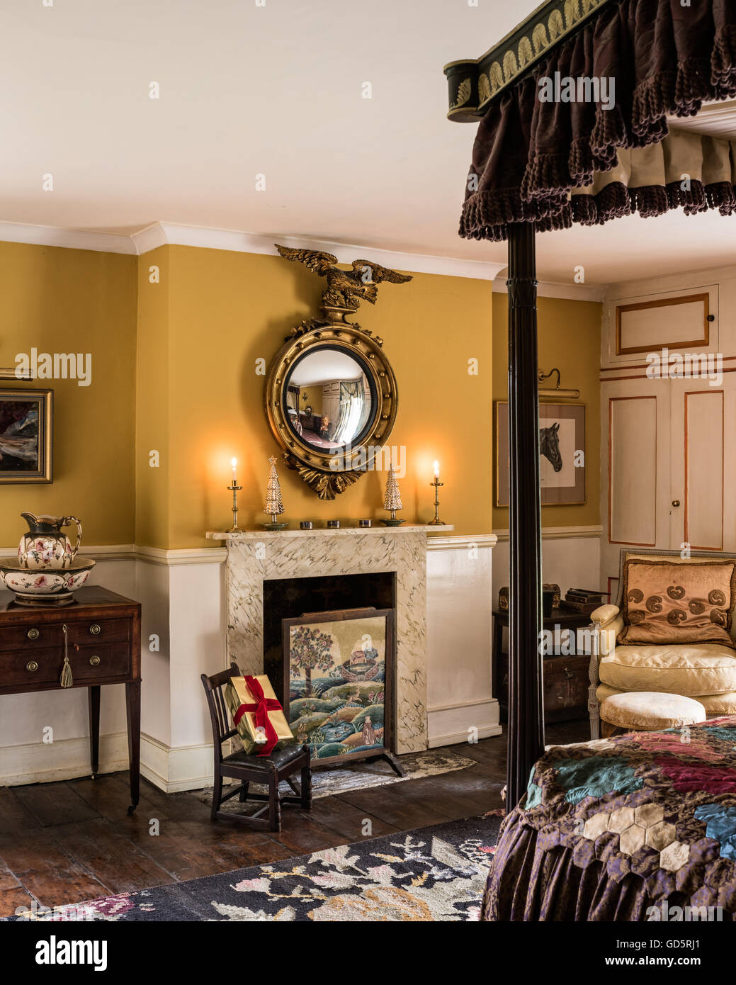 Regency Spiegel über Kamin mit der 1930er Jahre Ofenschirm mit antiken Himmelbett, 17. Jahrhundert Pfarrhaus bauen, Surrey Stockfoto