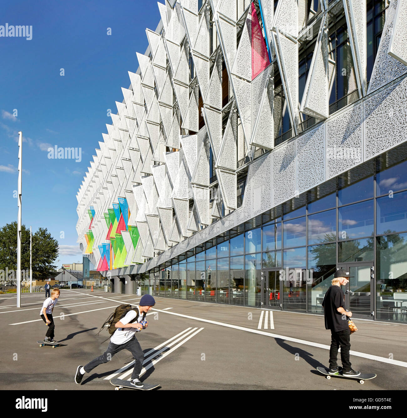 Perspektive entlang der Außenfassade mit Kindern Skateboard. SDU Campus Kolding, Kolding, Dänemark. Architekt: Henning Larsen Architects, 2015. Stockfoto