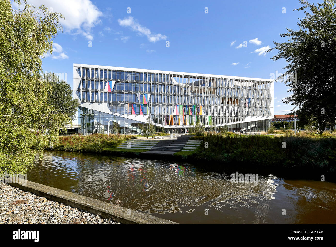 Blick über den Fluss Kolding in Richtung Garten und Gebäude. SDU Campus Kolding, Kolding, Dänemark. Architekt: Henning Larsen Architects, 2015. Stockfoto
