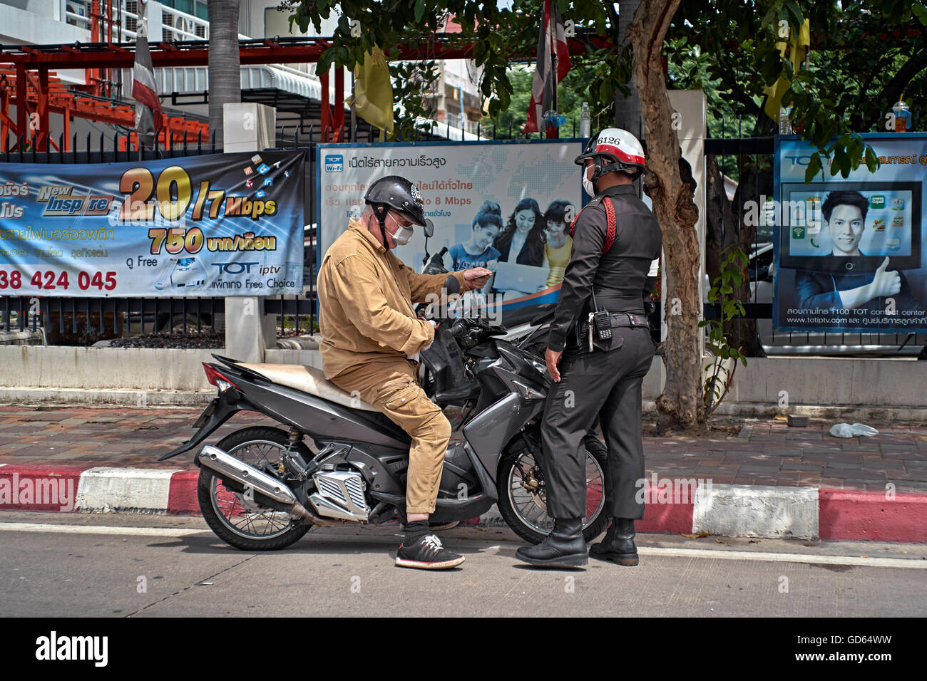Polizei Thailand. Motorradfahrer wurde wegen Verkehrsverstößen vom thailändischen Polizeibeamten angehalten. Thailand S. E. Asien Stockfoto