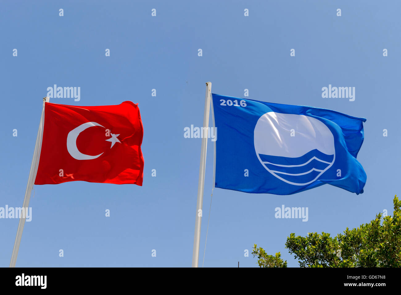 Sauber, Strand sauber Wasser blaue Flagge und die türkische Fahne in Bodrum, Türkei. Stockfoto