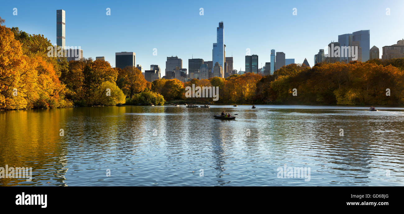 Verlieben Sie sich im Central Park in The Lake Midtown Manhattan Wolkenkratzer. Panorama Stadtansicht mit bunten Herbstlaub in New York Stockfoto