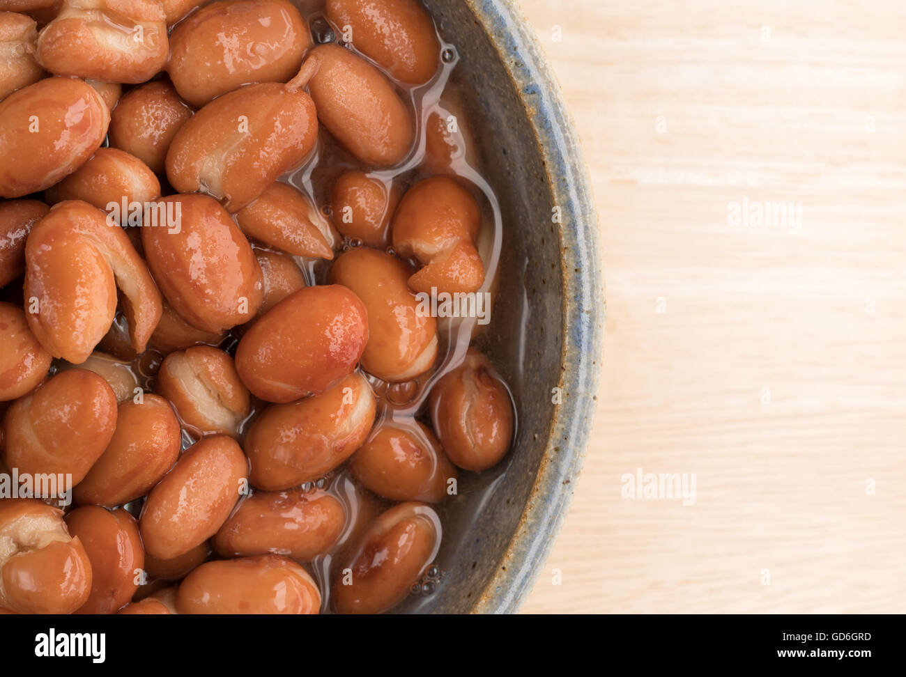 Enge Draufsicht einer Portion geschälten Bohnen auf einem Holztisch. Stockfoto