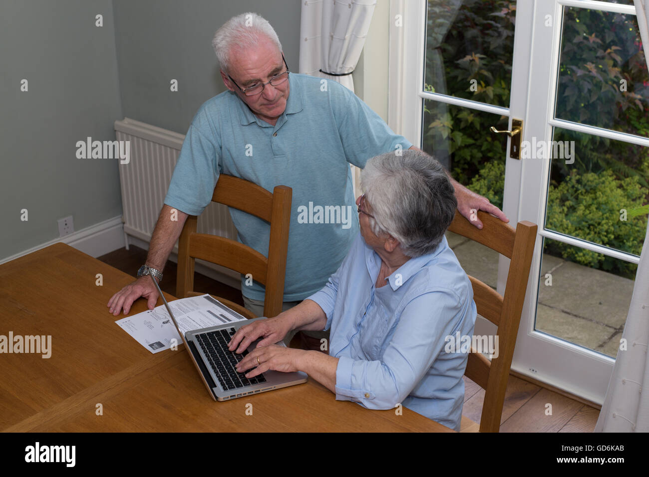 Alte im Alter Rentner mit einem Laptop-Computer, Mann und Frau, an den Esstisch zu Hause. Stockfoto