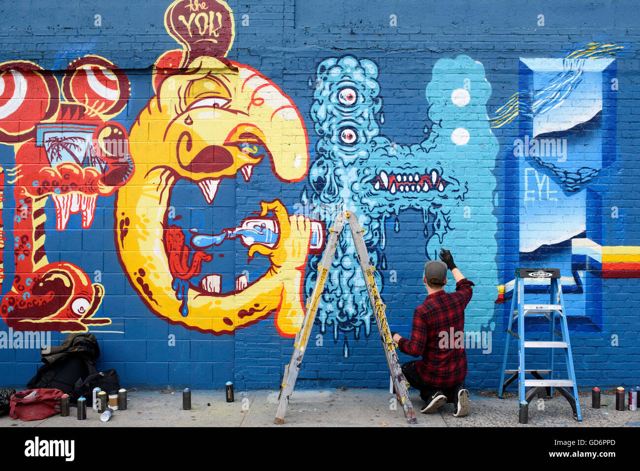 Künstler arbeiten auf ein Wandbild auf Avenue C East 6th Street auf der Lower East Side am Montagnachmittag. Die Wandmalerei, die von Künstlern Yok und Sheryo konzipiert wurde, ist ein sanktionierten Projekt von Greg Edgell Jersey City ansässige Green Bösewicht organisiert. Stockfoto