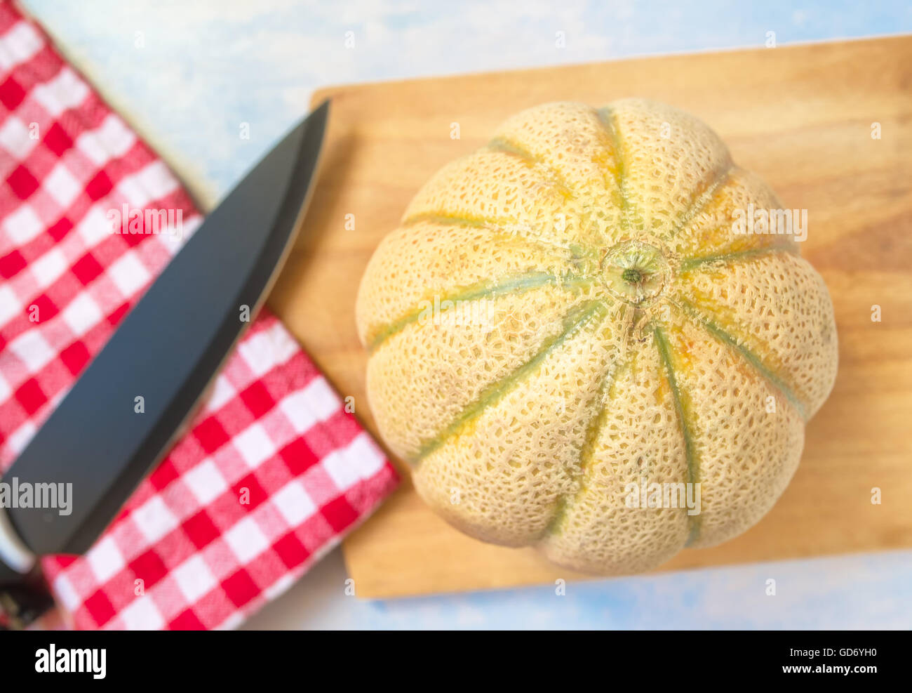 Cantaloupe Melone und Küche Messer auf rustikalen Holztisch, ganze Früchte an Bord, selektiven Fokus Stockfoto