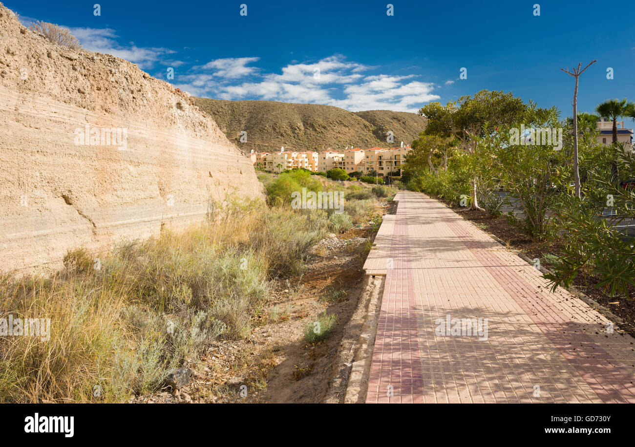Fußweg in Los Cristianos, Teneriffa mit kleinen Klippe von prähistorischen, antiken pyroklastische Ablagerungen Stockfoto