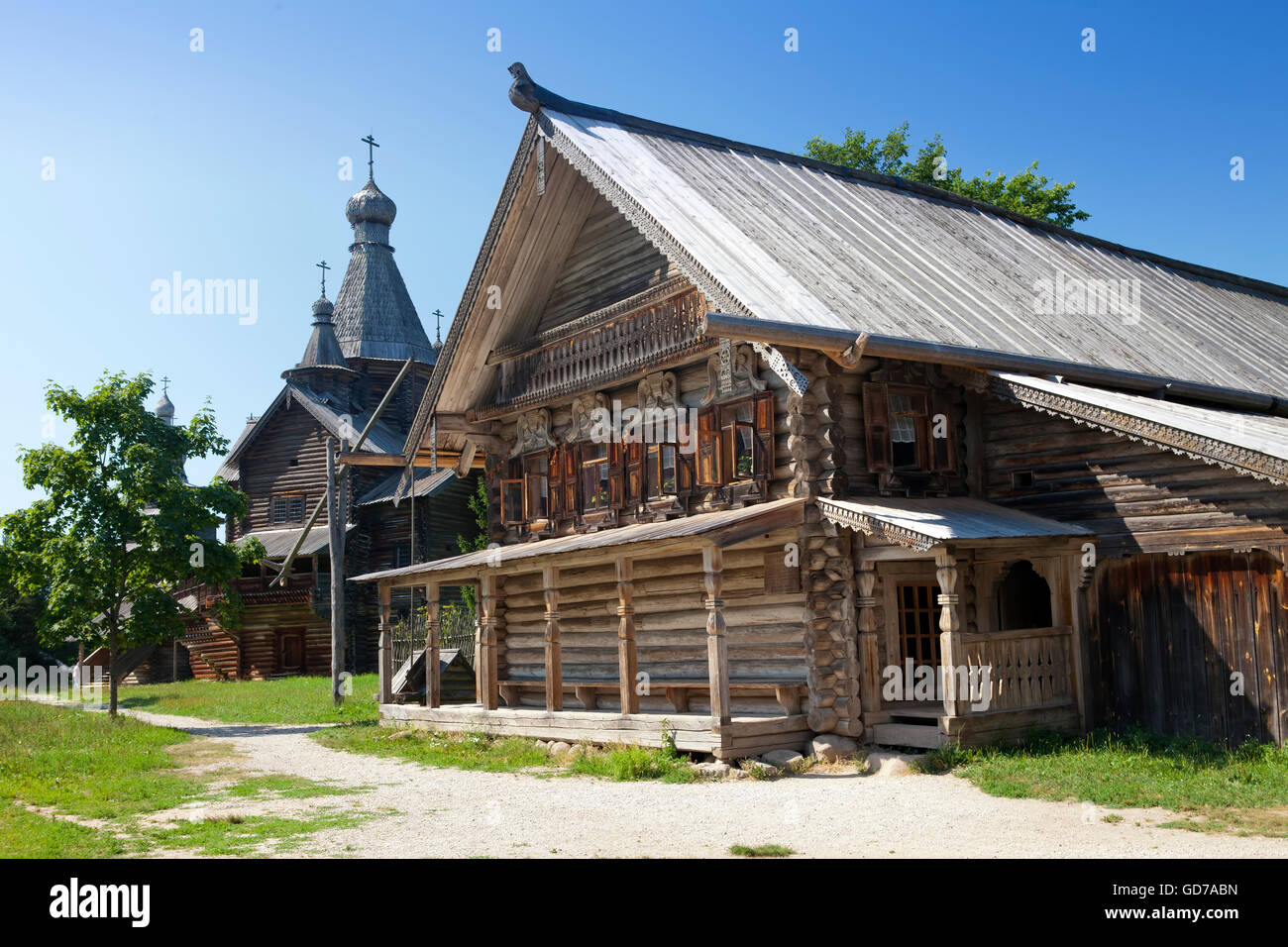 Alte hölzerne Kirche und Holzscheit Hütte auf einer Waldlichtung. Russland. Stockfoto