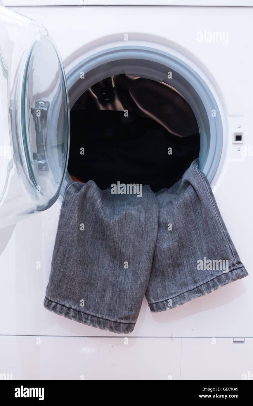 Eine Nahaufnahme von einer Waschmaschine beladen mit Kleidung. Haushaltsgerät. Stockfoto